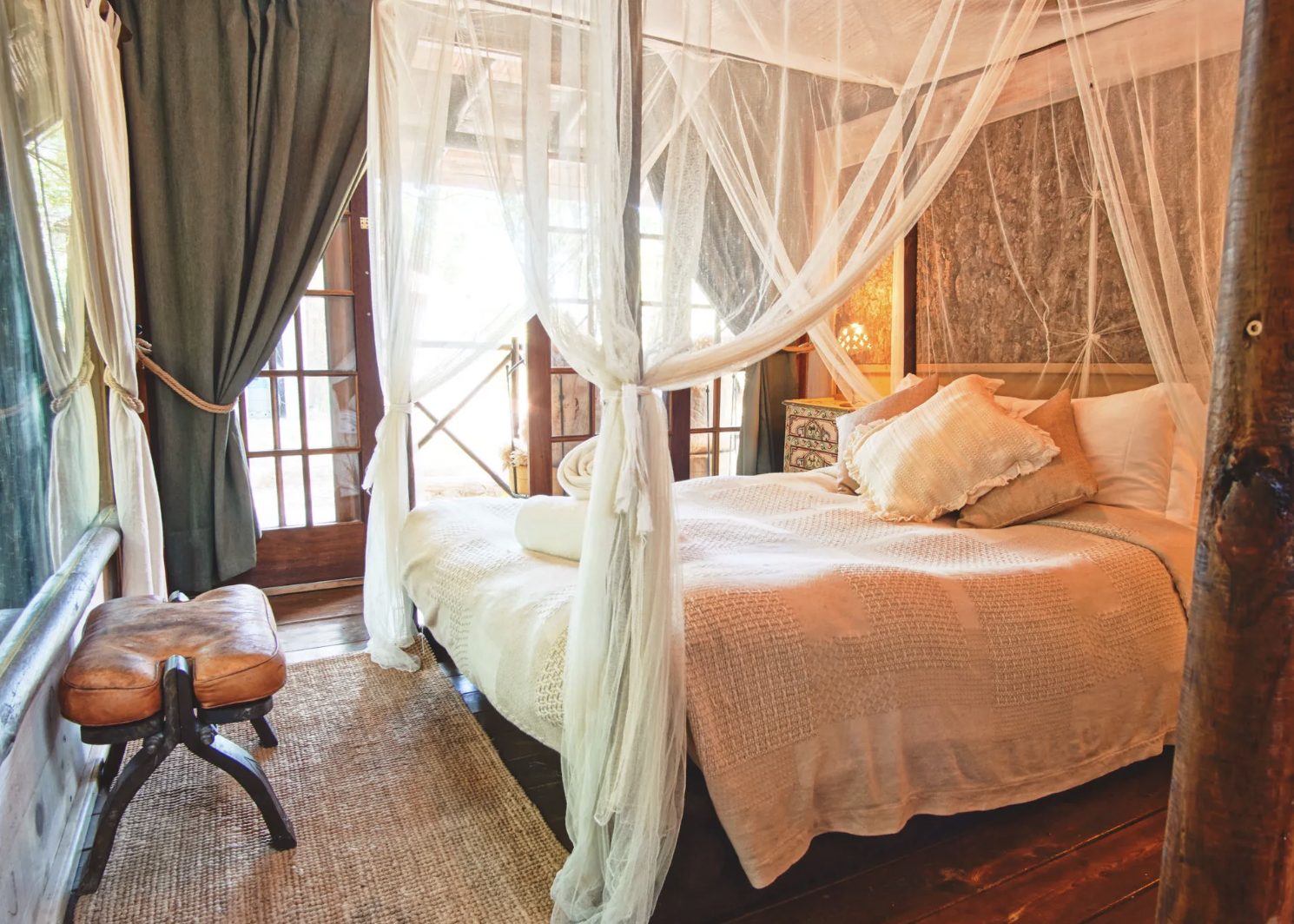 Couples cabin bedroom view through wooden doors at Aterra