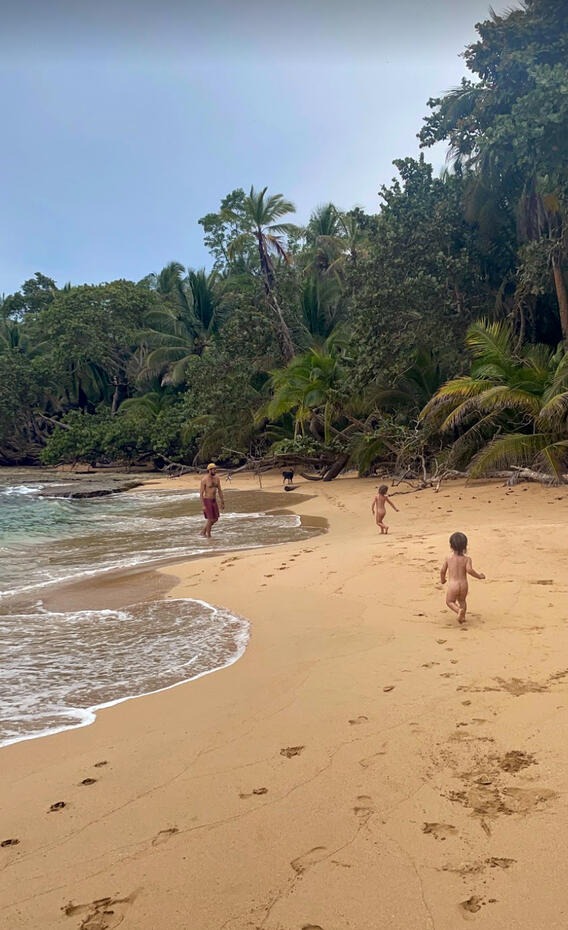 Parent and children on pristine tropical beach with palm trees at Casa de Mono