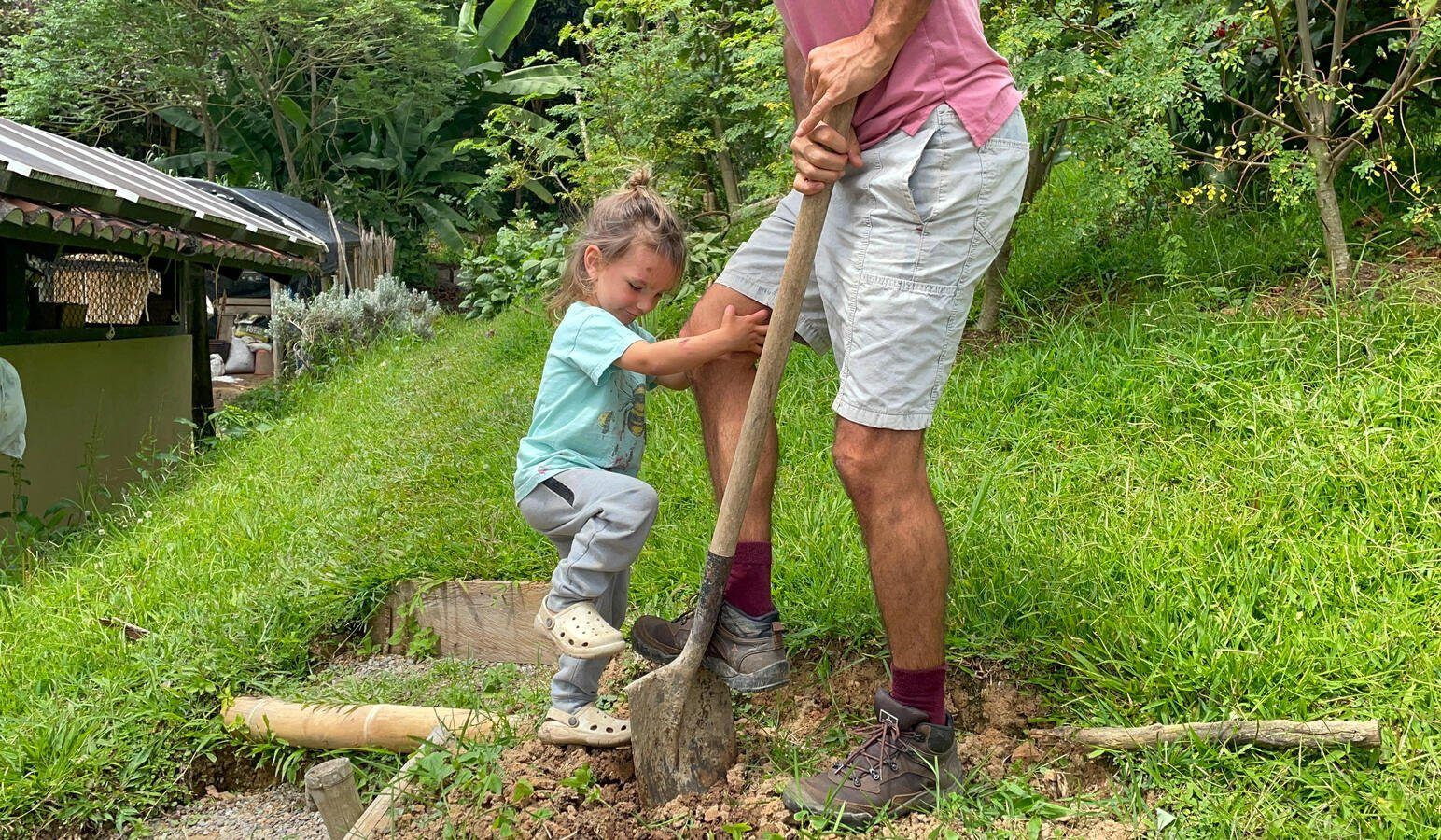 Elder and child digging in the garden together
