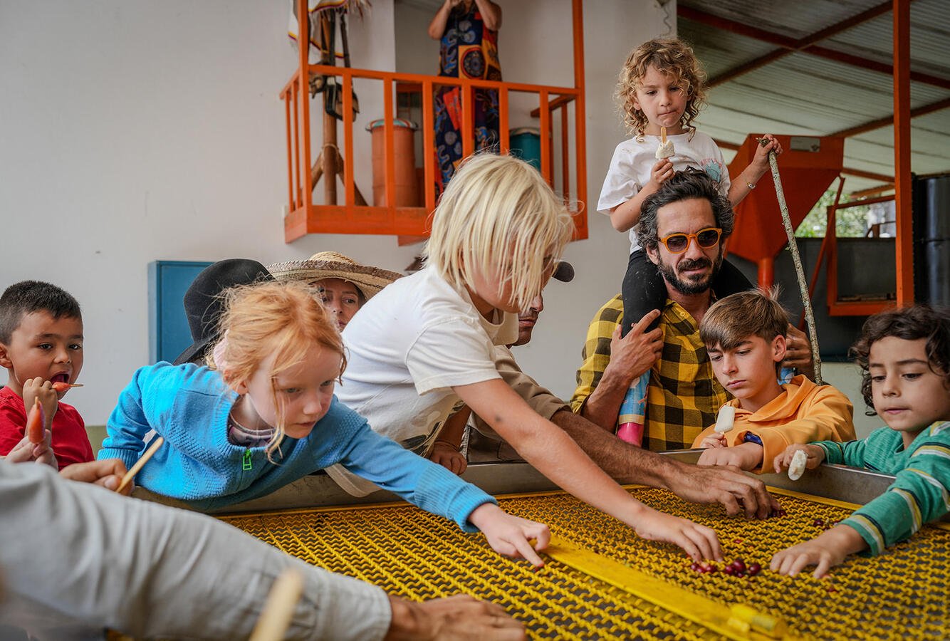 Children and adults sorting coffee beans in a workshop