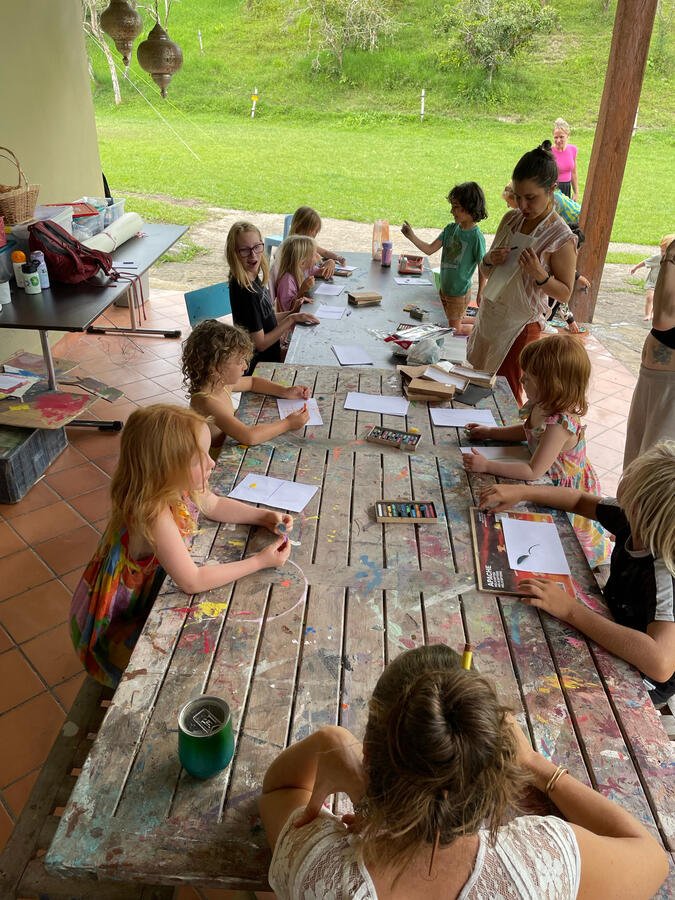 Children painting together at the outdoor art table
