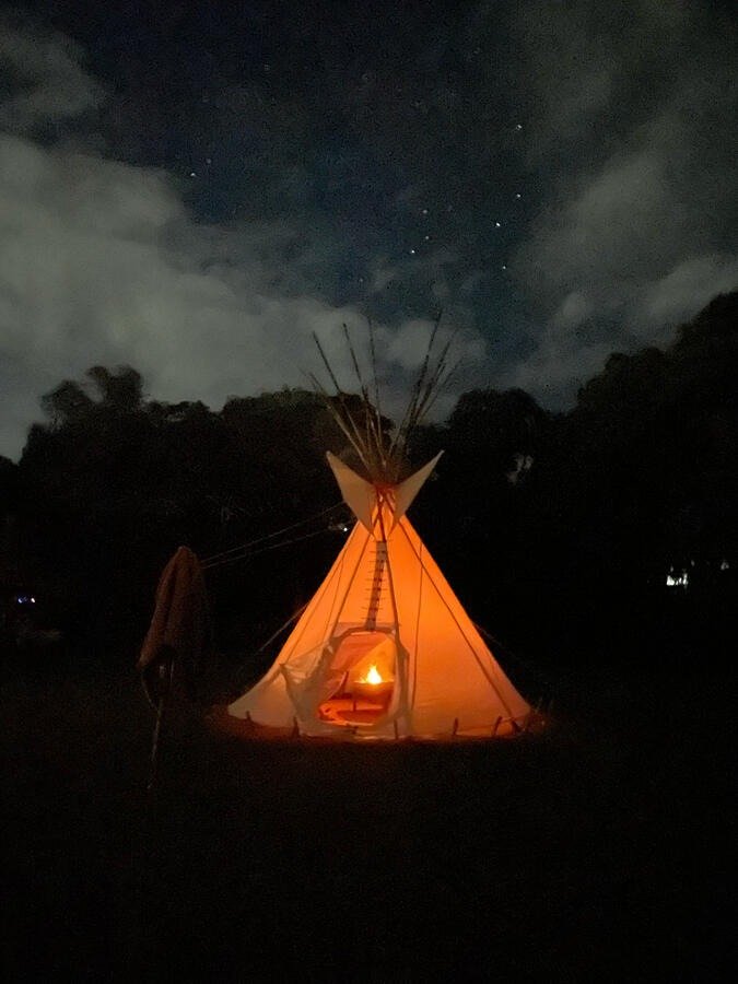Illuminated tipi at night with stars above, Casa Sumapaz